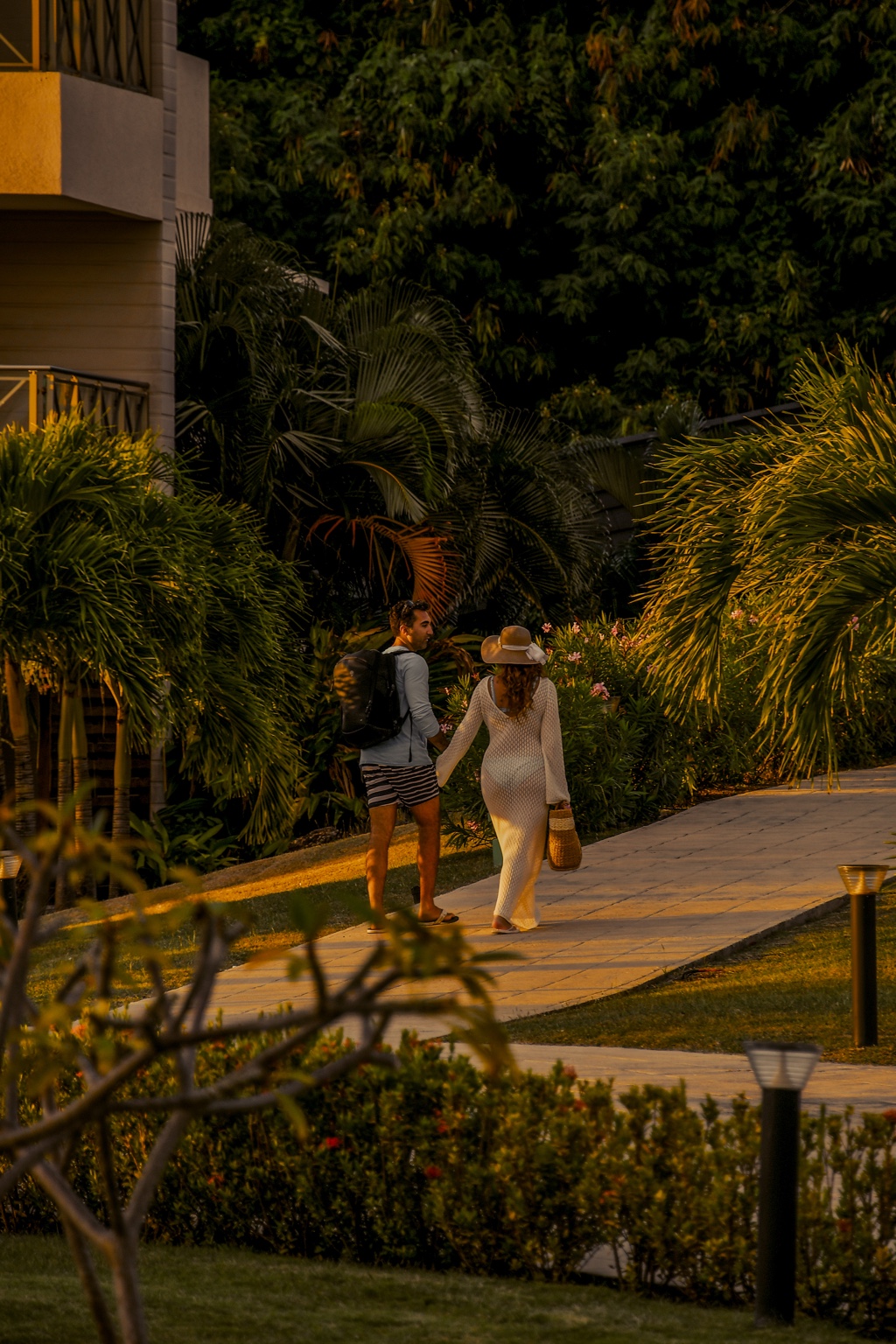 Two guests walking through tropical gardens