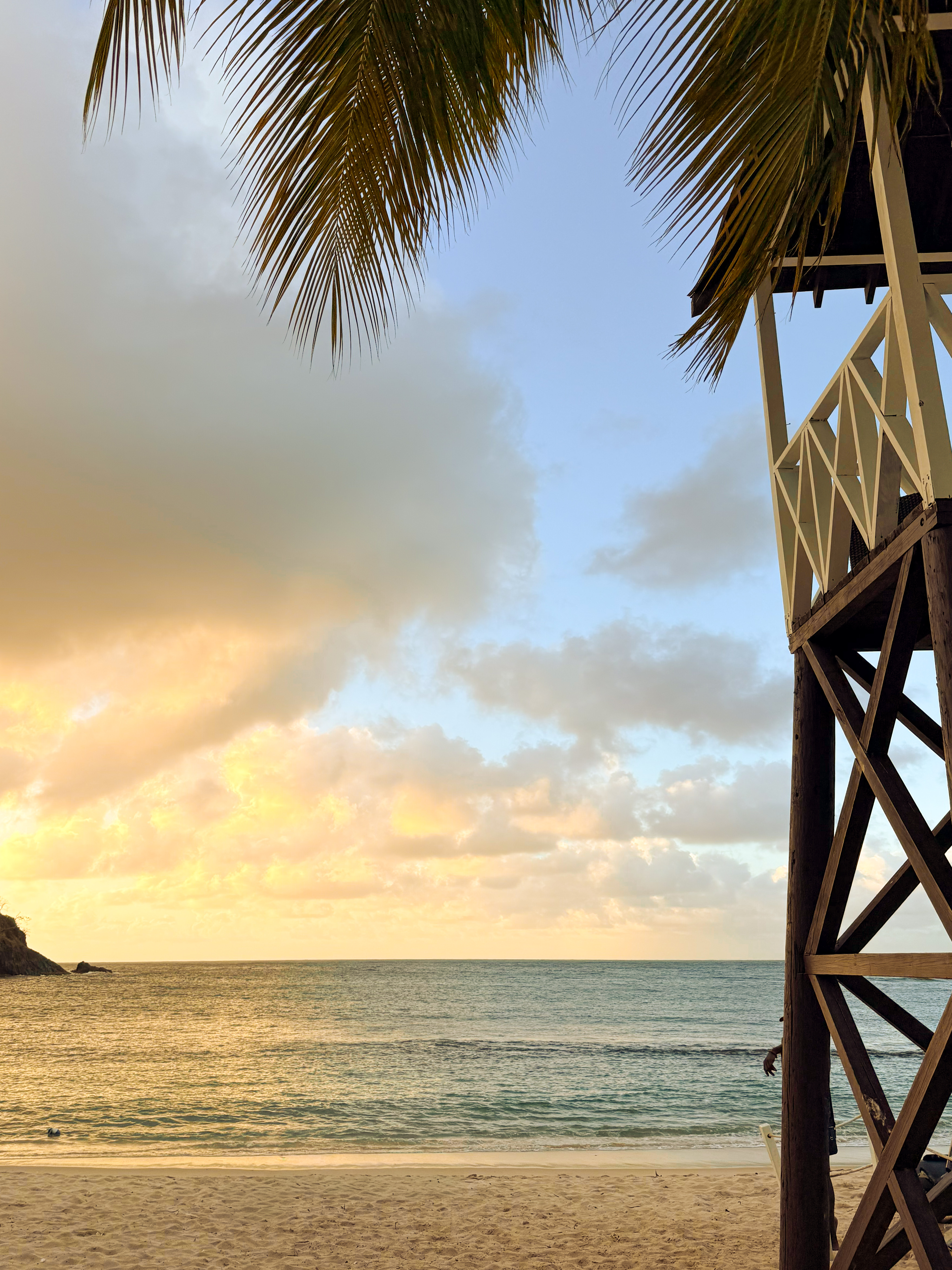 Caribbean beach at golden hour with palm and lifeguard tower, St. Lucia