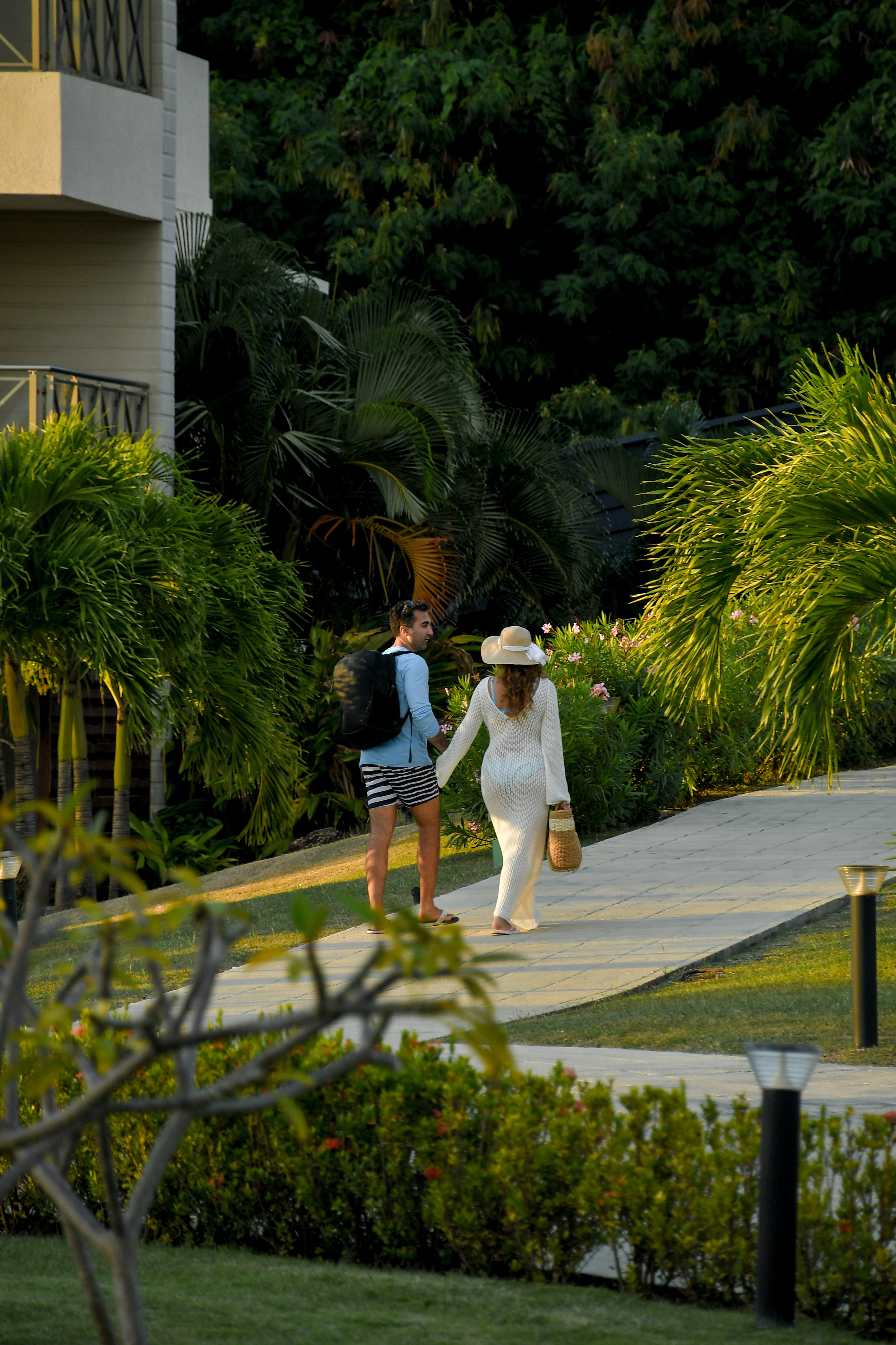 Guests walking through a tropical resort path